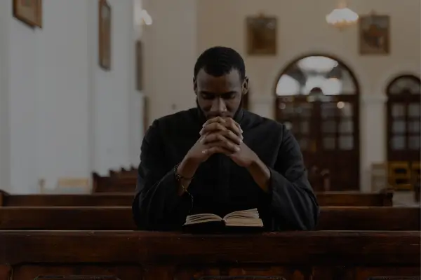 Homem em oração expressando confiança em Deus em meio às dificuldades.