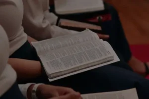 Pessoas reunidas lendo a Bíblia em grupo, simbolizando o estudo bíblico diário e a busca por crescimento espiritual.