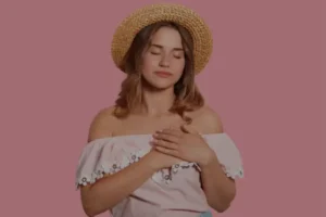 Mulher com a mão no coração refletindo sobre o que é amor segundo a Bíblia