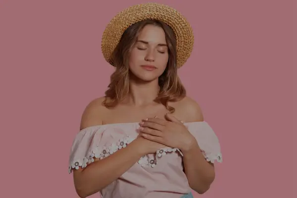 Mulher com a mão no coração refletindo sobre o que é amor segundo a Bíblia