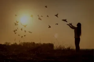 Mulher soltando pombas, representando simbolicamente o que é o Espírito Santo como presença de paz, liberdade e direção divina.